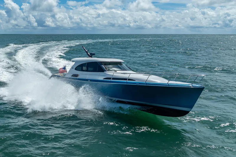 Slide: The Image of 2019 Palm Beach Motor Yachts GT50 cruising on open water under a cloudy sky. - 61