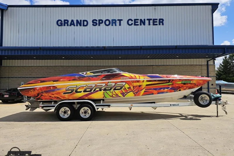 The Image of 1995 Wellcraft 29 Scarab boat with vibrant graphics at Grand Sport Center. - 1