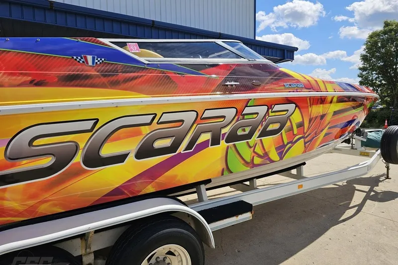 Slide: The Image of Colorful 1995 Wellcraft 29 Scarab boat on trailer under blue sky. - 10