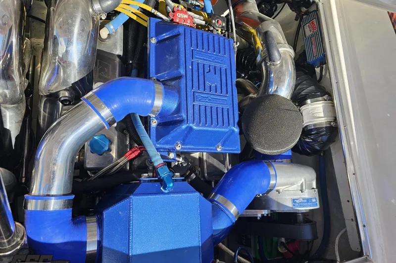 Slide: The Image of Engine compartment of a 1995 Wellcraft 29 Scarab with blue hoses and components. - 101