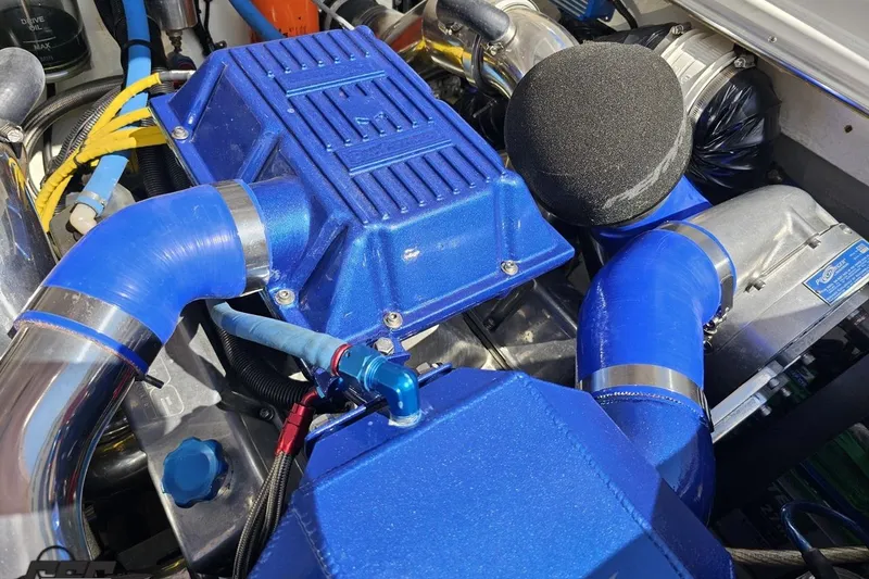 Slide: The Image of Engine compartment of a 1995 Wellcraft 29 Scarab with blue components and hoses. - 104