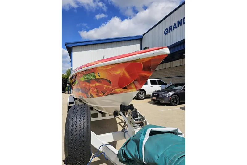 Slide: The Image of 1995 Wellcraft 29 Scarab boat with vibrant flame graphics on a trailer. - 15