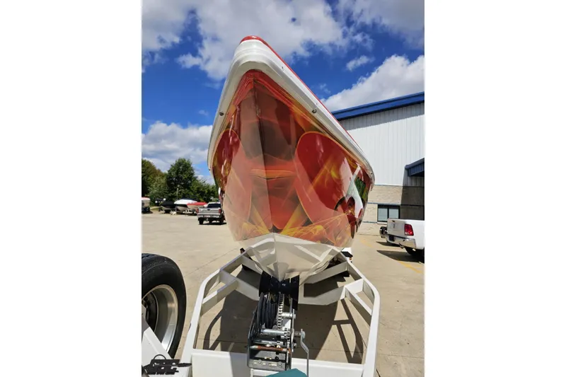 Slide: The Image of 1995 Wellcraft 29 Scarab boat with vibrant graphics on a trailer, under a blue sky. - 16