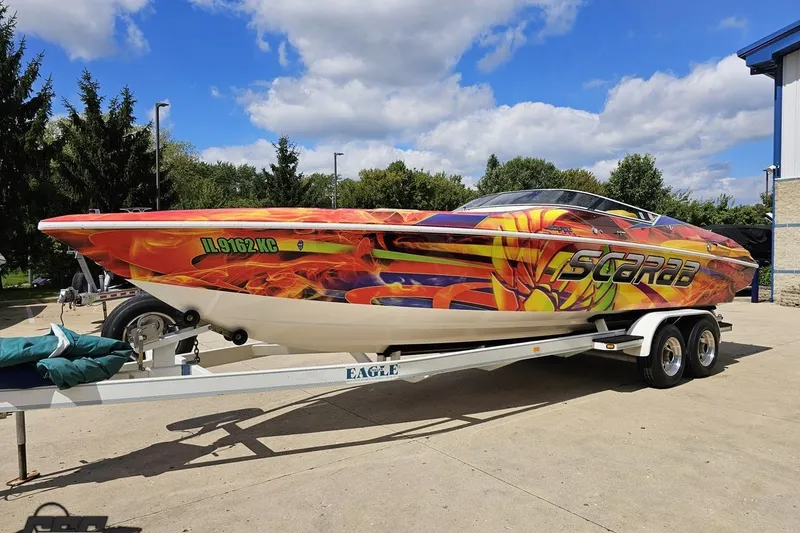 Slide: The Image of 1995 Wellcraft 29 Scarab boat with vibrant custom graphics on a trailer. - 17