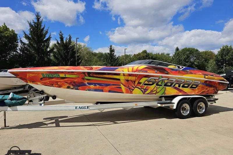 Slide: The Image of Colorful 1995 Wellcraft 29 Scarab boat on trailer under blue sky. - 19