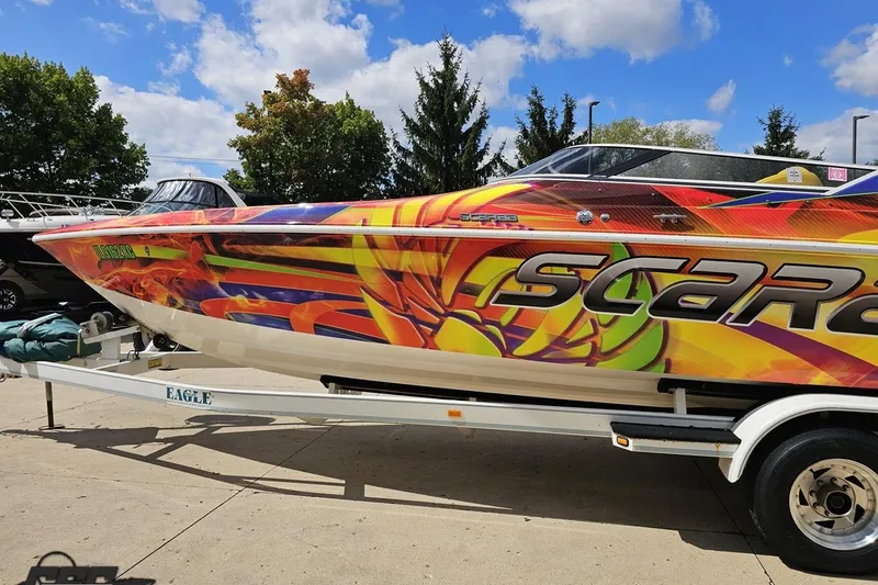 Slide: The Image of Colorful 1995 Wellcraft 29 Scarab boat on trailer, vibrant graphics, sunny day. - 22