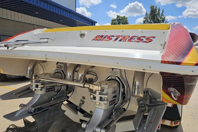 Slide: The Image of 1995 Wellcraft 29 Scarab boat with dual engines, labeled "Mistress," under a clear blue sky. - 31
