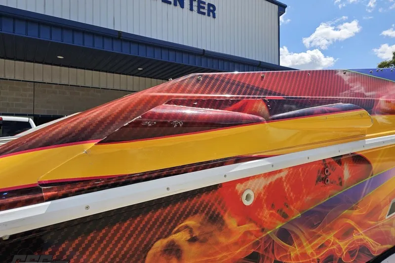 Slide: The Image of 1995 Wellcraft 29 Scarab boat with vibrant flame graphics and carbon fiber accents. - 33