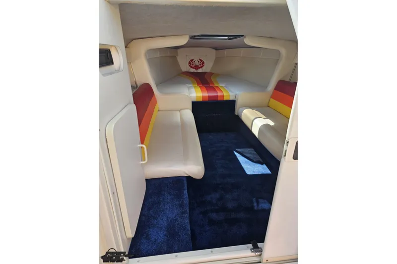 Slide: The Image of Interior of 1995 Wellcraft 29 Scarab boat with colorful seating and blue carpet. - 72