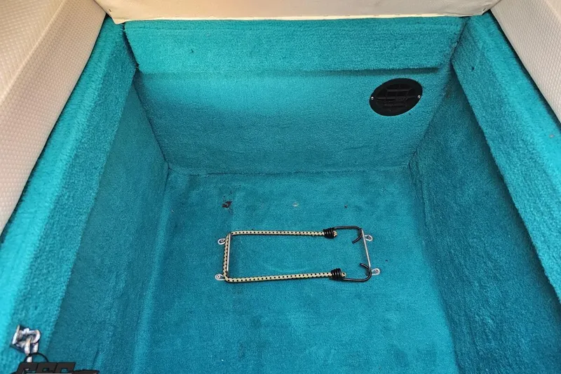 Slide: The Image of Interior of 1995 Wellcraft 29 Scarab boat with teal carpet and storage compartment. - 79