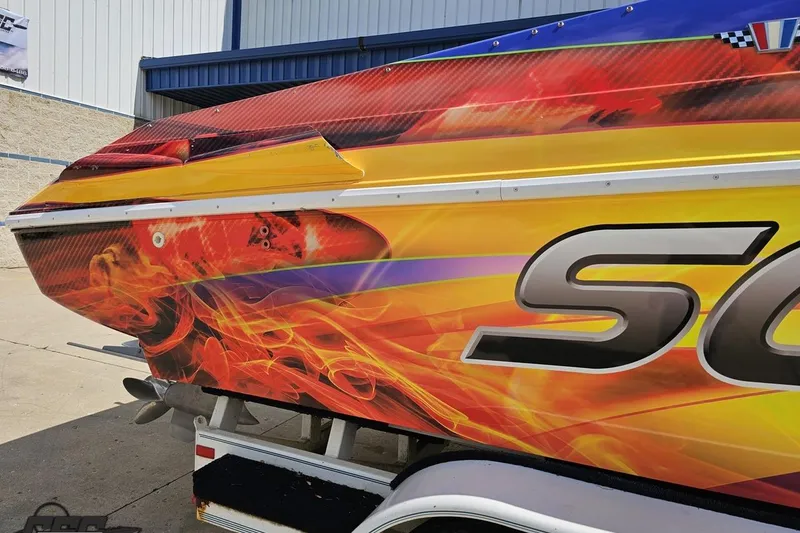 Slide: The Image of 1995 Wellcraft 29 Scarab boat with vibrant flame graphics on the side. - 9