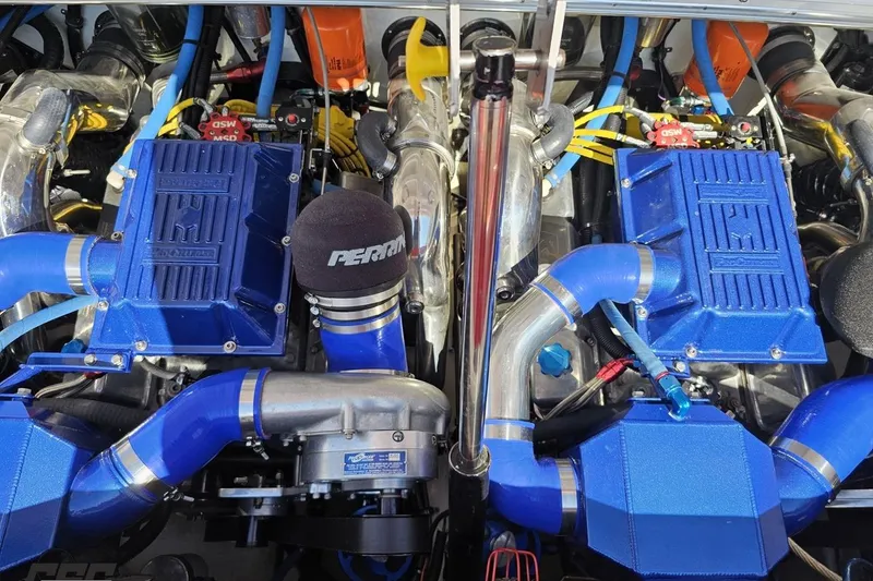 Slide: The Image of Twin blue engines in a 1995 Wellcraft 29 Scarab boat, showcasing performance components. - 98