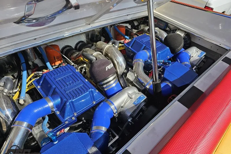 Slide: The Image of Twin engines in a 1995 Wellcraft 29 Scarab boat, featuring blue components and chrome details. - 99