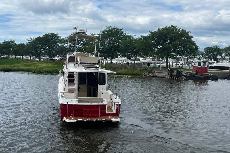 Slide: The Image of 2026 Ranger Tugs R-31 Command Bridge Luxury Edition on a serene waterway. - 10