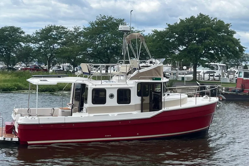 Slide: The Image of 2026 Ranger Tugs R-31 Command Bridge Luxury Edition in vibrant red on a serene waterway. - 11
