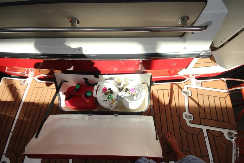 Slide: The Image of 2026 Ranger Tugs R-31 Command Bridge storage compartment with fuel and propane tanks on deck. - 13