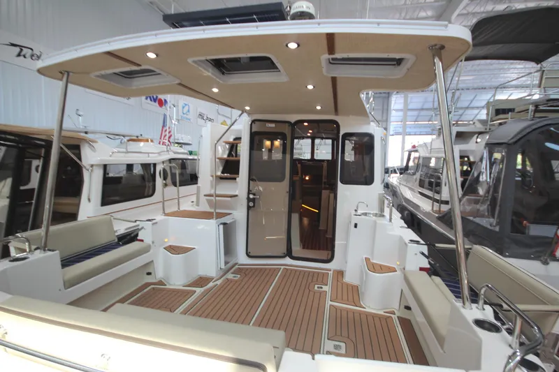 Slide: The Image of 2026 Ranger Tugs R-31 Command Bridge Luxury Edition boat interior with seating and wood flooring. - 16