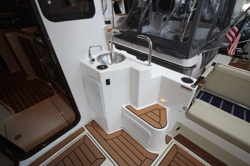 Slide: The Image of 2026 Ranger Tugs R-31 Command Bridge Luxury Edition interior with sink and seating area. - 19