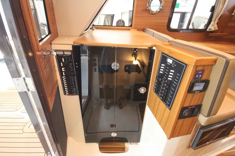 Slide: The Image of Interior of 2026 Ranger Tugs R-31 Command Bridge, featuring control panels and wood finish. - 27