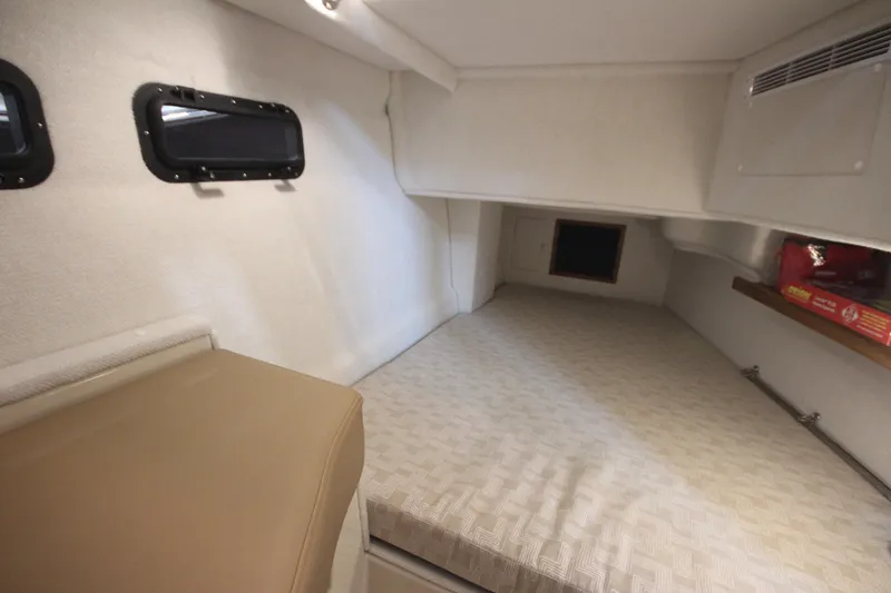 Slide: The Image of 2026 Ranger Tugs R-31 Command Bridge Luxury Edition interior cabin with bed and portholes. - 32