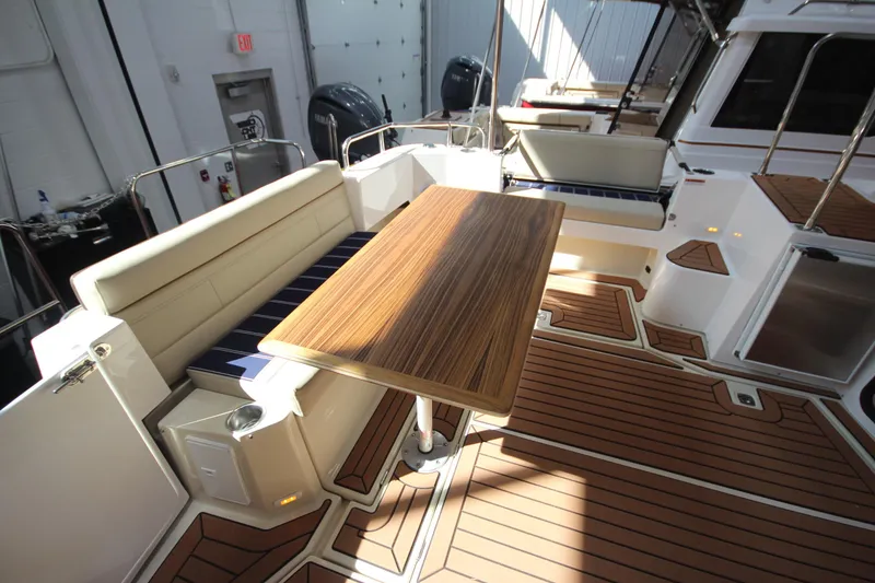 Slide: The Image of 2026 Ranger Tugs R-31 Command Bridge Luxury Edition with elegant deck seating and wooden table. - 37