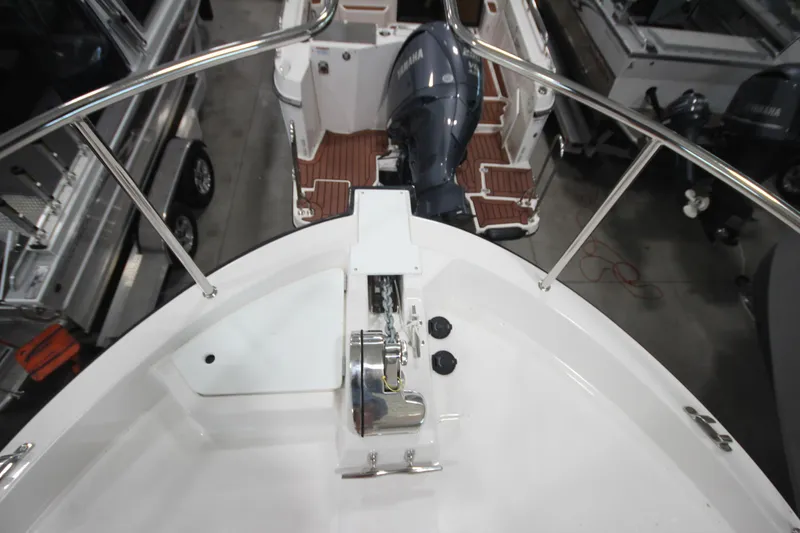Slide: The Image of 2026 Ranger Tugs R-31 Command Bridge Luxury Edition boat deck with motor and railing. - 47