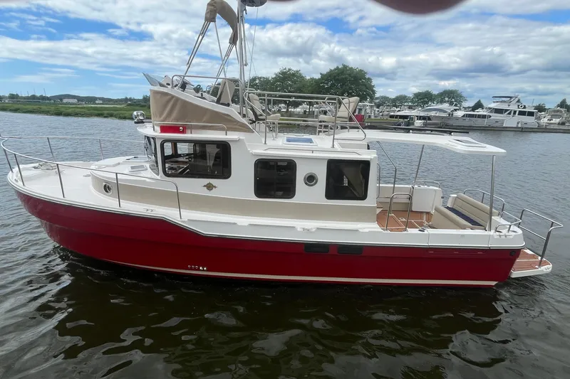 Slide: The Image of 2026 Ranger Tugs R-31 Command Bridge Luxury Edition on water, showcasing sleek design and vibrant red hull. - 5