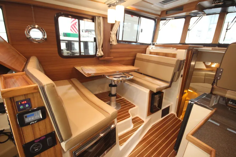 Slide: The Image of Interior of 2026 Ranger Tugs R-31 Command Bridge, featuring luxurious seating and wood finishes. - 51