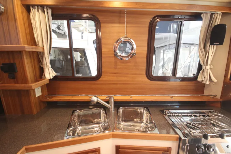 Slide: The Image of Luxurious kitchen interior of 2026 Ranger Tugs R-31 Command Bridge, featuring wood finish and modern appliances. - 54