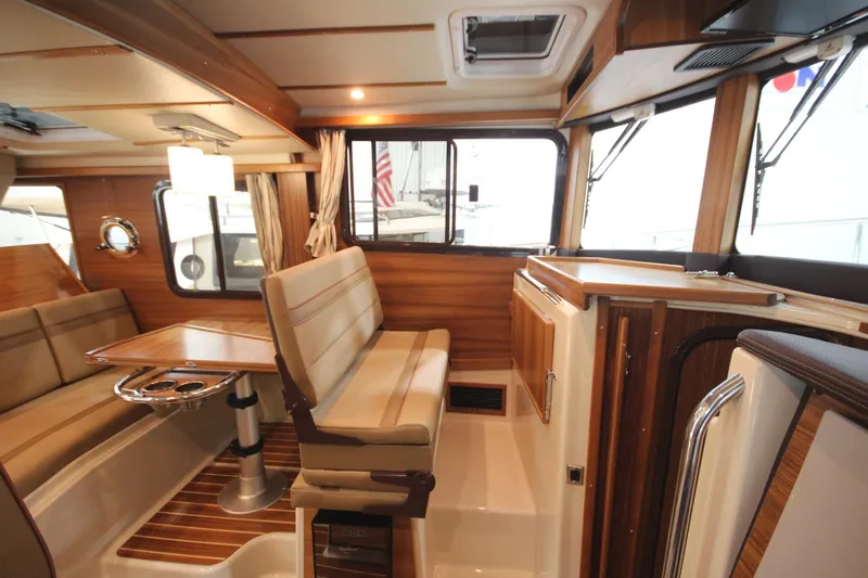 Slide: The Image of Interior of 2026 Ranger Tugs R-31 Command Bridge, featuring luxurious seating and wood finishes. - 56