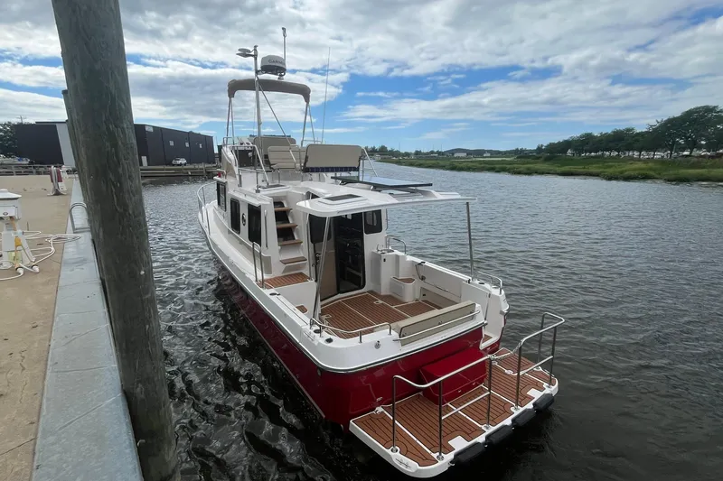 Slide: The Image of 2026 Ranger Tugs R-31 Command Bridge Luxury Edition docked on a calm river. - 6