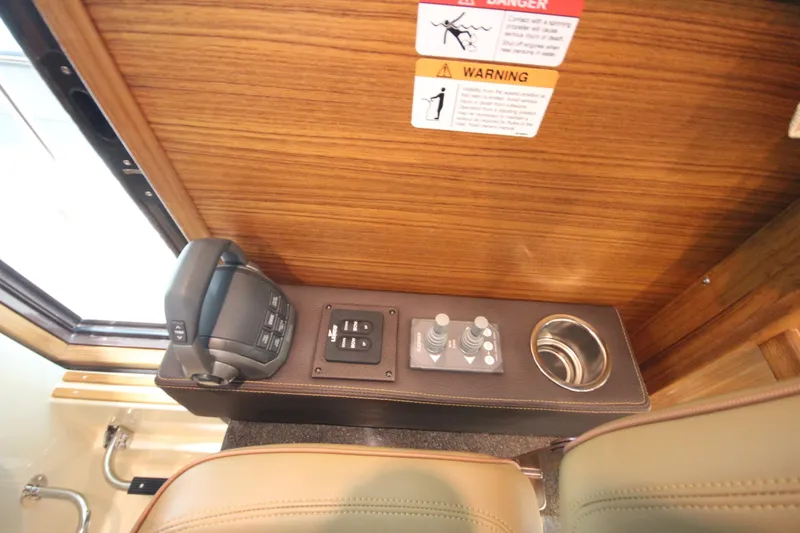 Slide: The Image of Control panel of 2026 Ranger Tugs R-31 Command Bridge Luxury Edition with joystick and cup holder. - 60