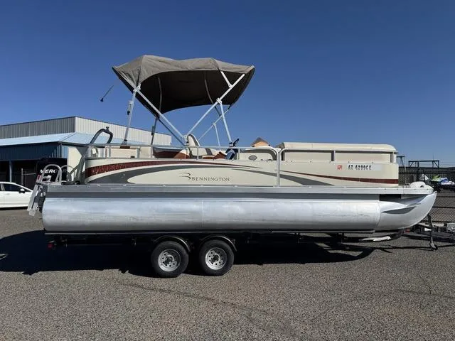 Slide: The Image of 2007 Bennington 2275 GL pontoon boat on trailer, parked outdoors under clear sky. - 2