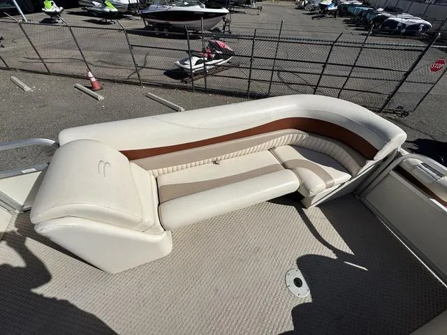 Slide: The Image of 2007 Bennington 2275 GL boat with beige and brown seating, docked near a fenced area. - 25