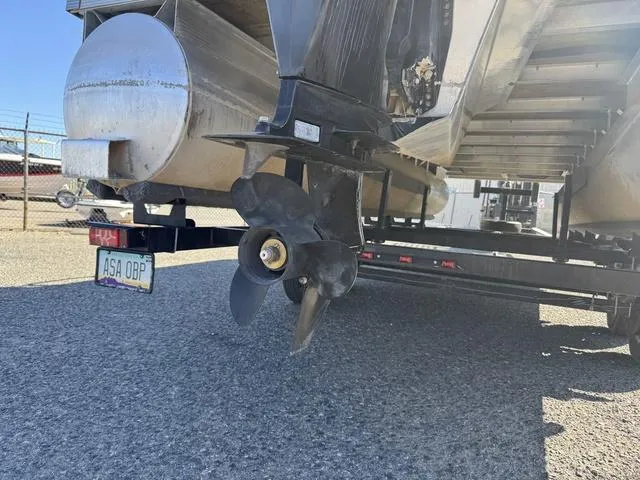Slide: The Image of 2007 Bennington 2275 GL pontoon boat propeller and trailer, parked on gravel surface. - 6