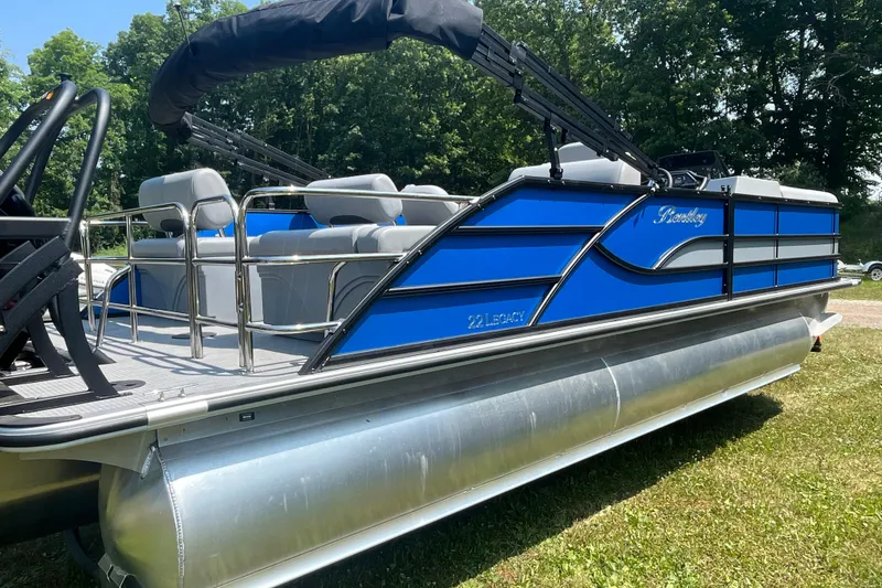 Slide: The Image of 2025 Bentley Pontoons Legacy QSB pontoon boat in blue, parked on grass. - 6