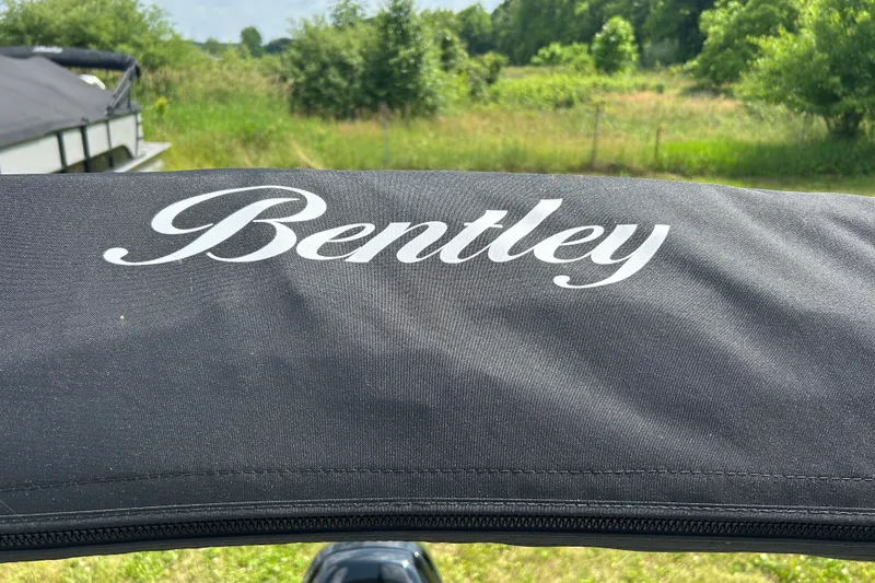 Slide: The Image of Bentley Pontoons LE 180 3PT 2025 logo on black fabric, outdoor background. - 25