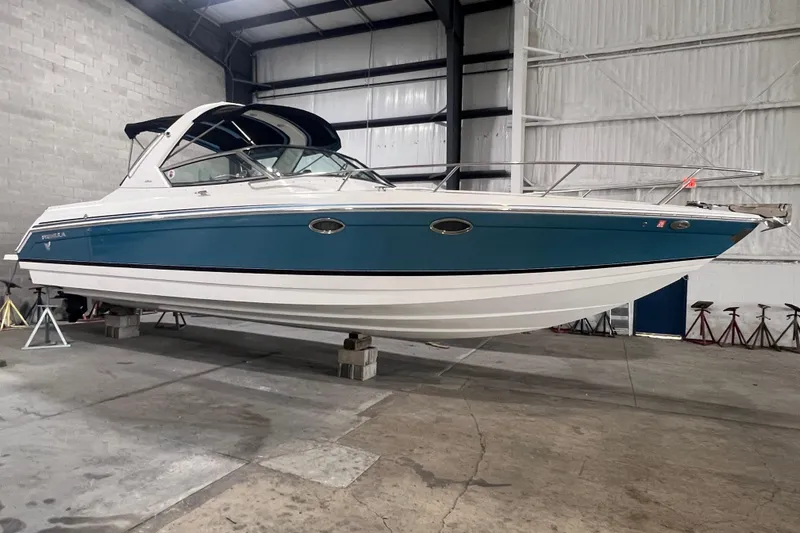 The Image of 2005 Formula 330 Sun Sport boat in indoor storage, blue and white exterior. - 0