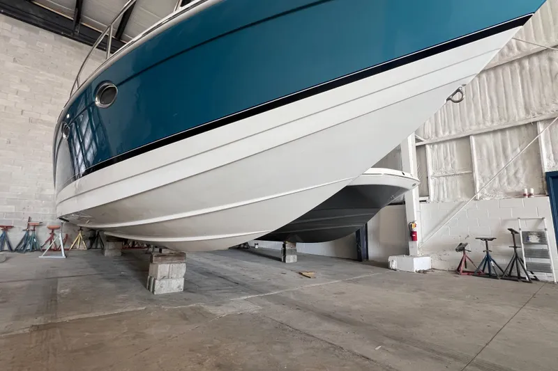 Slide: The Image of 2005 Formula 330 Sun Sport boat in storage, elevated on blocks in a warehouse. - 2