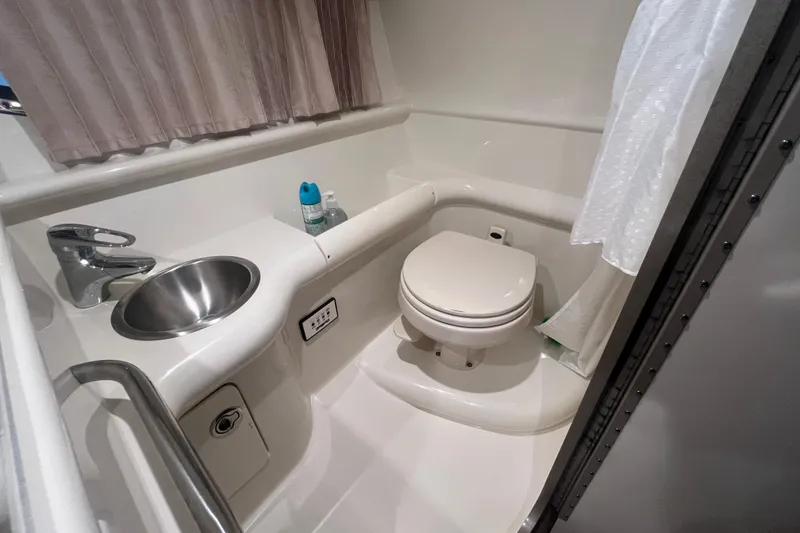 Slide: The Image of 2005 Formula 330 Sun Sport boat bathroom with sink, toilet, and shower curtain. - 21