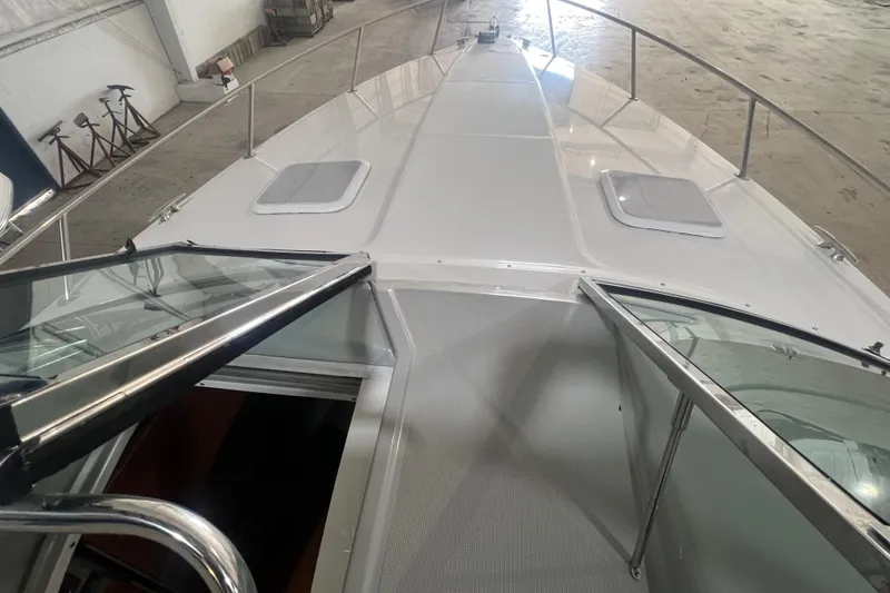 Slide: The Image of 2005 Formula 330 Sun Sport boat deck with open hatch and railing in a warehouse. - 6