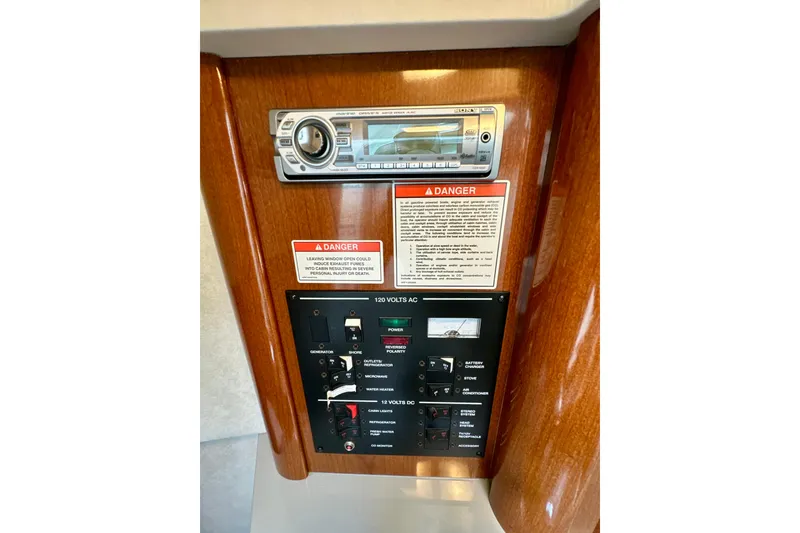 Slide: The Image of Control panel of 2012 Sea Ray 240 Sundancer boat with stereo and warning labels. - 14