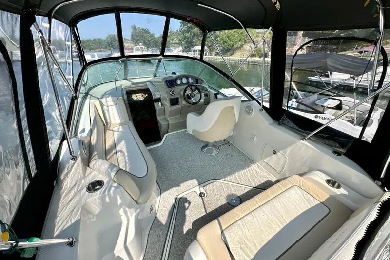 Slide: The Image of Interior of 2012 Sea Ray 240 Sundancer boat with seating and steering wheel. - 2