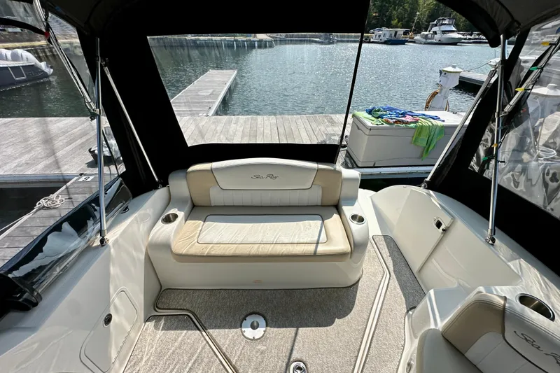 Slide: The Image of 2012 Sea Ray 240 Sundancer interior with seating, docked at a marina. - 3