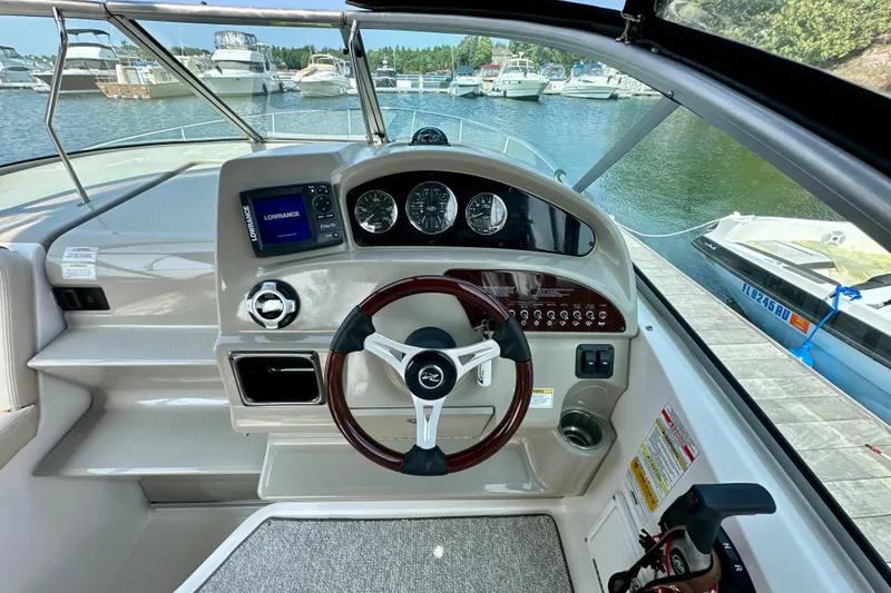 Slide: The Image of Cockpit of 2012 Sea Ray 240 Sundancer with steering wheel and navigation instruments. - 4