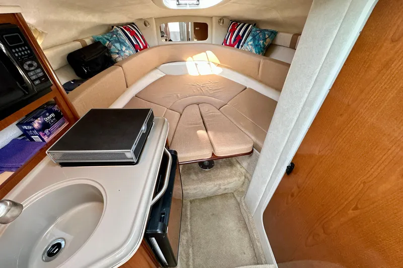Slide: The Image of Interior of 2012 Sea Ray 240 Sundancer boat with cozy seating and kitchenette. - 6