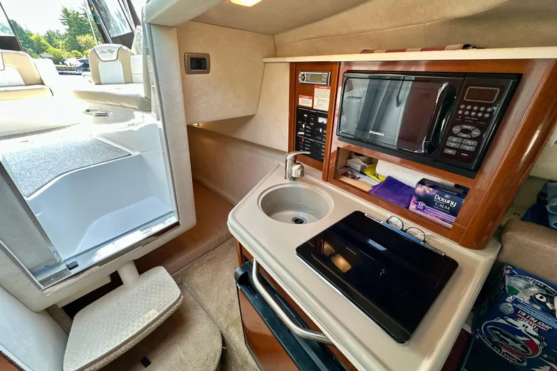 Slide: The Image of Interior of 2012 Sea Ray 240 Sundancer with kitchenette, sink, and microwave. - 7