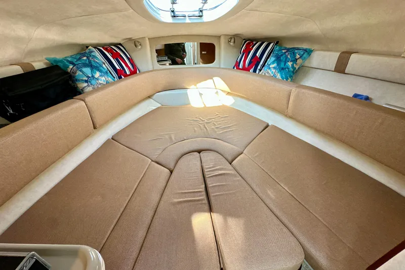 Slide: The Image of Interior cabin of 2012 Sea Ray 240 Sundancer with beige seating and decorative pillows. - 8