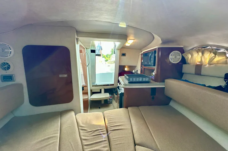 Slide: The Image of Interior of 2012 Sea Ray 240 Sundancer boat with cozy seating and kitchenette. - 9