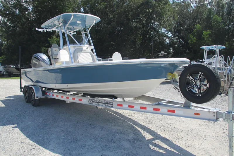 Slide: The Image of 2026 Avenger AV26 boat on trailer, blue and white design, parked outdoors. - 5